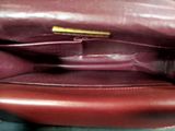 the inside of a brown purse with a gold handle