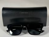 une paire de lunettes de soleil noires posée sur un étui noir