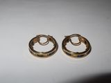 two small gold hoop earrings with blue stones on a white surface