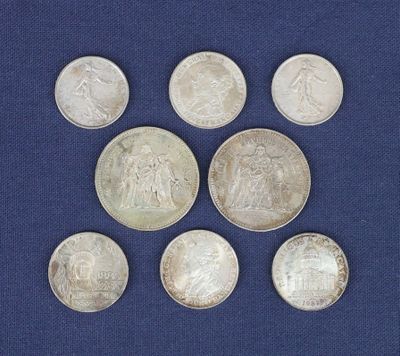 six pièces d'argent sont disposées en cercle sur un fond bleu