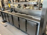 a large stainless steel kitchen with many dishes on the counter
