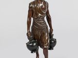 statue en bronze représentant un homme tenant deux pots et un bol