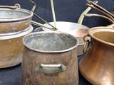 several pots and pans are lined up on a black surface