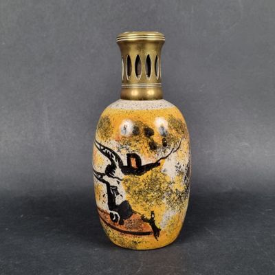 an image of a yellow vase with a black and white painting on it