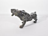 une petite statue représentant un chien posée sur une surface blanche