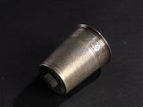 a silver cup that is sitting on a black surface