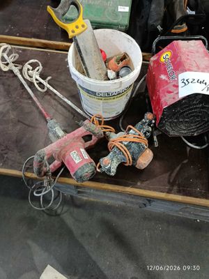 a table with tools and a bucket of paint on it