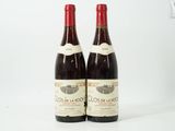 deux bouteilles de vin rouge posées l'une à côté de l'autre sur une surface blanche