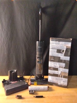 une photo d'un aspirateur posé sur une table à côté d'une boîte
