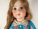 a close up of a doll wearing a dress and a hat