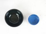 a black bowl and a blue bowl on a white table