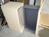 a small cabinet with a door open next to a chair
