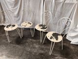 three white chairs with black spots on them sitting in front of a curtain