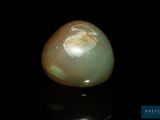 an image of a green jade stone on a black surface