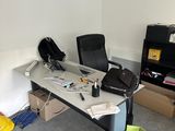 a desk with a chair and a laptop on it