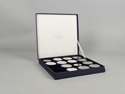 a close up of a box of coins on a white surface
