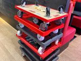 a red cart that has wheels on it in a room