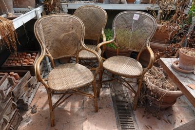 trois chaises en osier posées sur une terrasse en briques