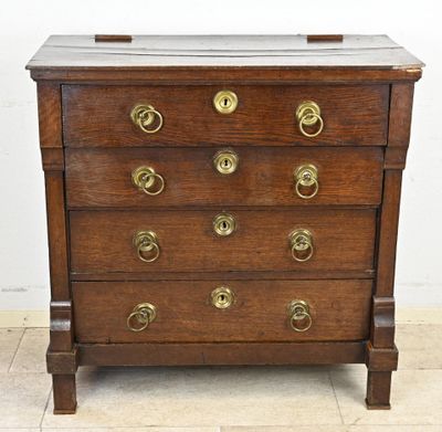 une commode ancienne en bois avec des poignées en laiton sur les tiroirs