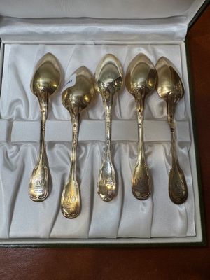 five spoons in a box on a table