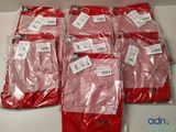 six paires de pantalons rouges sont emballées dans des sacs en plastique sur une table