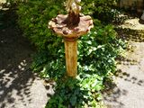 un bain d'oiseaux au milieu d'un jardin
