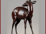 statue d'un cerf posée sur un socle en bois et encadrée d'un cadre rouge