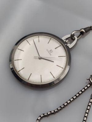 a silver pocket watch with a chain around it