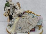 a figurine of a man and a woman sitting on a couch