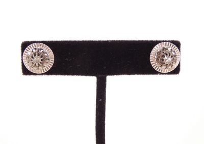 gros plan d'une paire de boucles d'oreilles sur un support noir