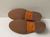 pair of brown slippers sitting on top of a white table