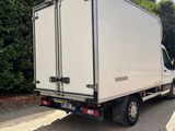 the truck is parked on the side of the road in front of a hedge