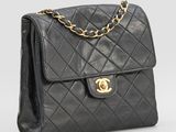 un sac à bandoulière Chanel en cuir matelassé noir, avec des finitions dorées