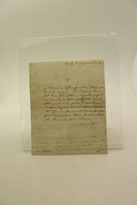 un vieux bout de papier posé sur une table, à côté d'une horloge