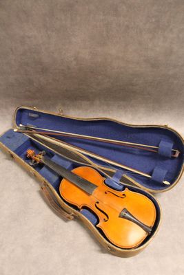 un violon orange repose dans un étui bleu posé sur une surface blanche