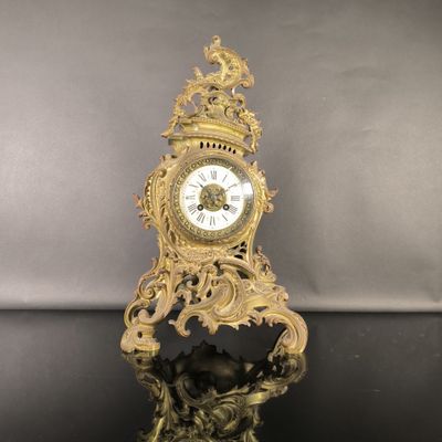 une horloge en or posée sur une table noire