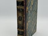 an old book sitting on top of a white surface