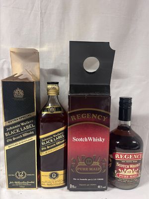 trois bouteilles de whisky et une boîte d'alcools posées sur une table