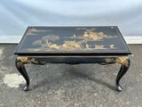 une table basse noire et dorée décorée d'oiseaux et de fleurs