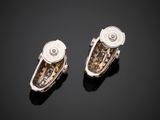 a pair of silver and gold earrings on a black surface