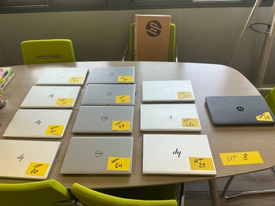 de nombreux ordinateurs portables posés sur la table, avec des autocollants jaunes dessus