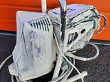 an old computer sitting on the ground next to an orange garage door