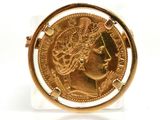 an image of a gold coin in a glass holder on a white surface