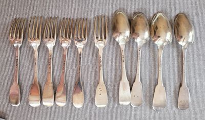 beaucoup de cuillères et de fourchettes en argent sur une table