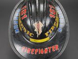 an old firefighter helmet with a red hat on top of it