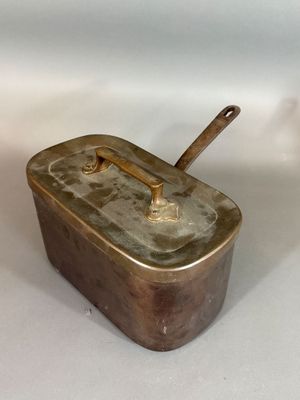 a metal container with a handle on a white surface