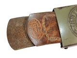 a belt with a metal buckle on it on a white surface