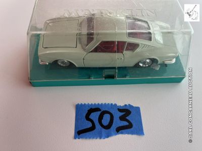 une petite voiture miniature dans une boîte transparente sur laquelle est collé un autocollant