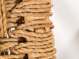 a close up of a wicker basket with a clock in the background