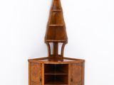 une armoire d'angle surmontée d'une étagère